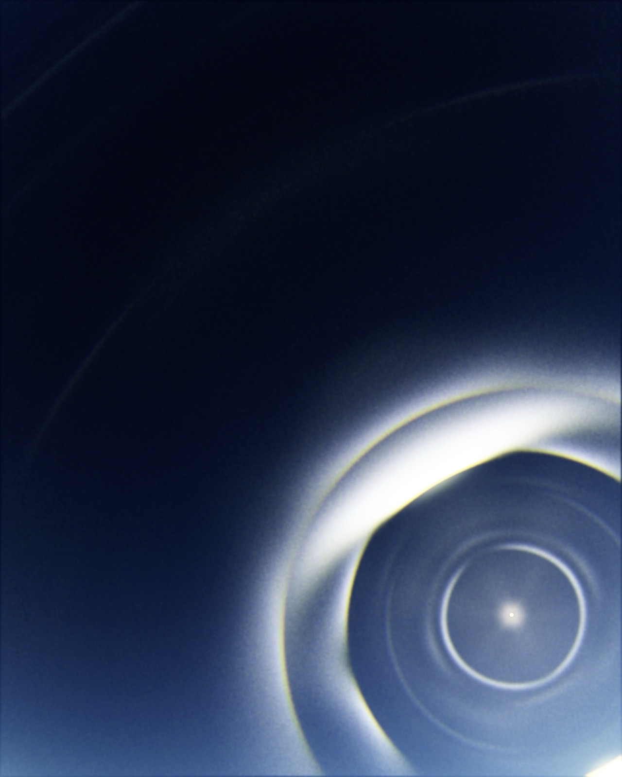 PARHELION plate 34 — the sun set low in the corner of a near-black sky, a single broad white halo sweeping away into darkness.